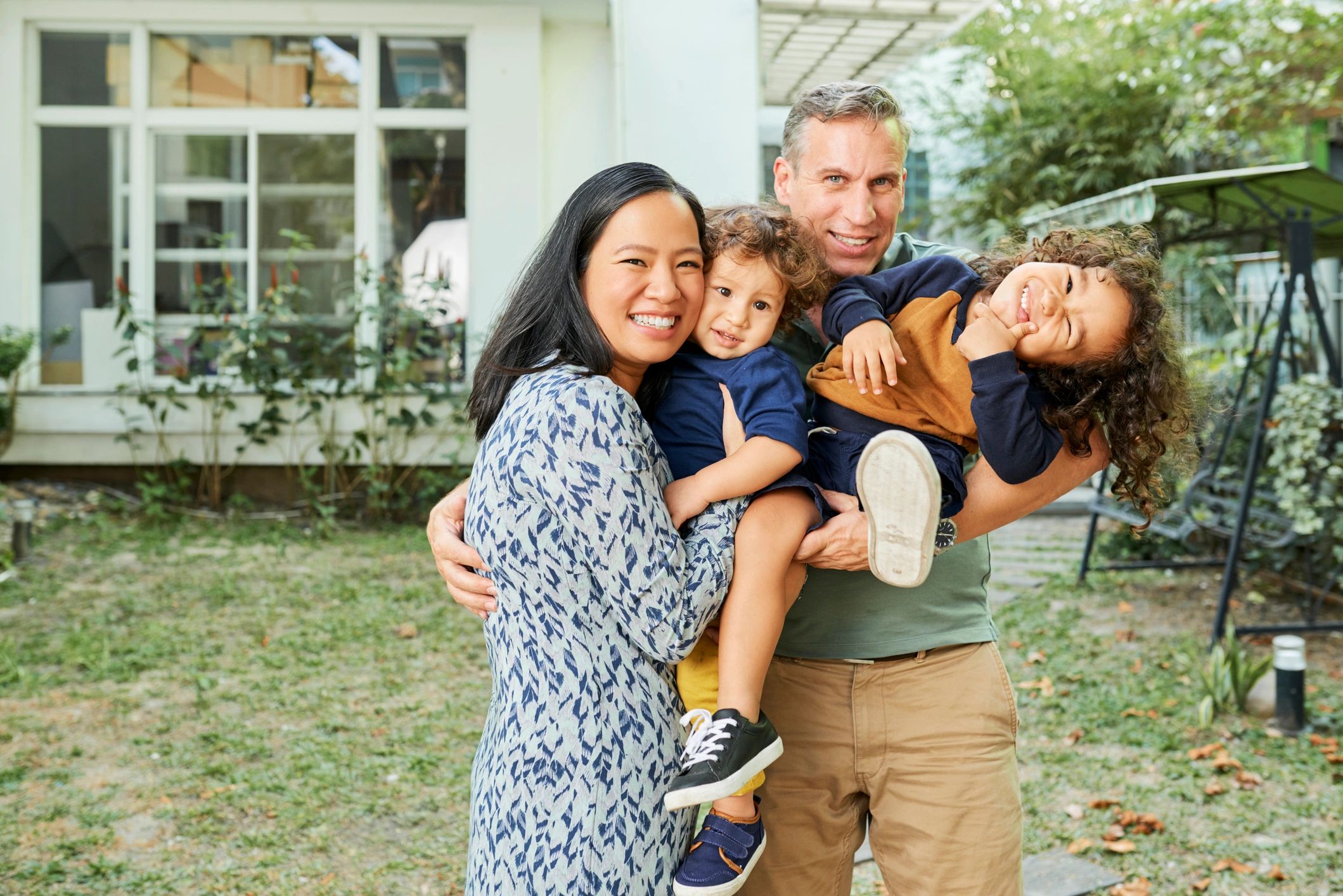 Family smiling together in a backyard