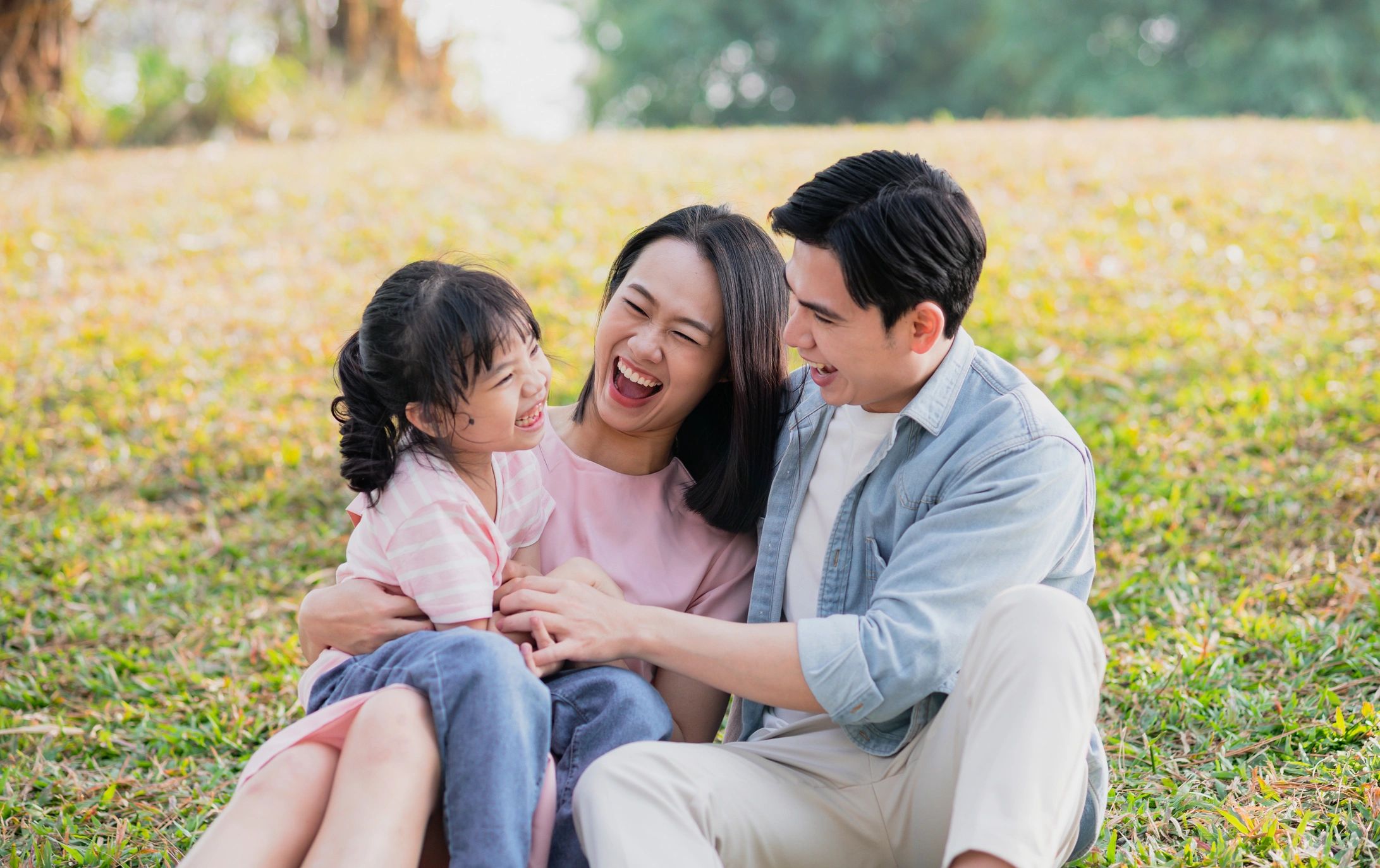 Family sitting on grass laughing together