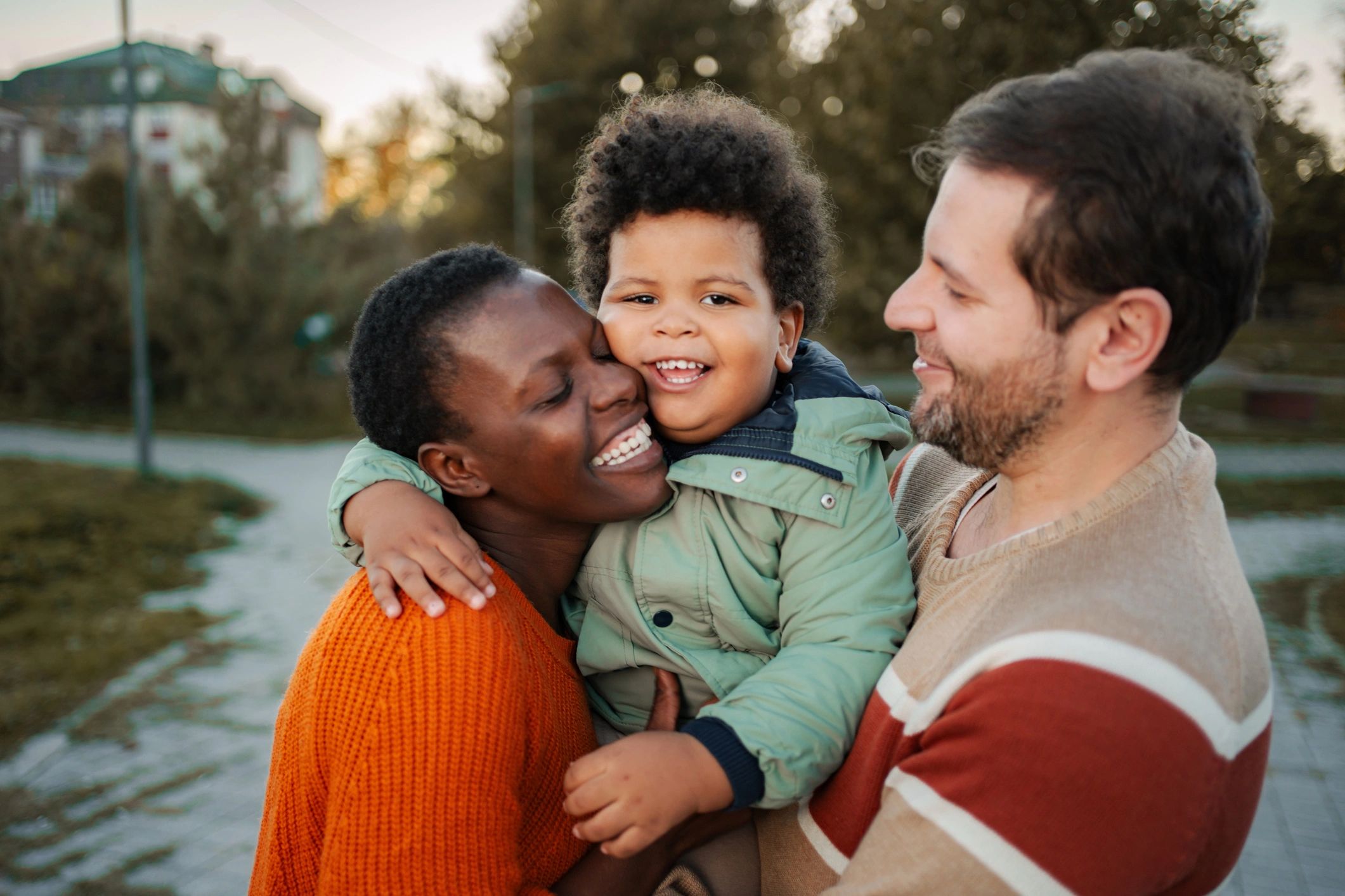 Family hugging and smiling in a park